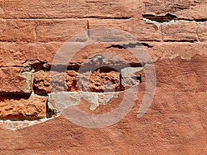 Red brick wall of an old building with crumbling plaster. Copy space. Selective focus