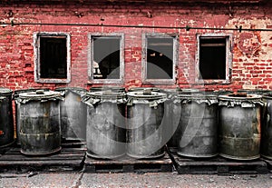 Red brick wall with plastic barrel outdoors