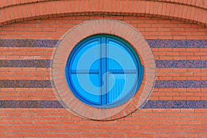 Red brick wall with round glassed window photo
