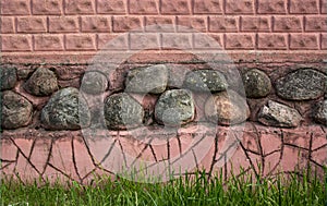 Red brick wall, stones in the middle