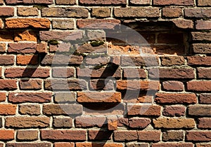 Red brick wall with a weathered appearance, featuring variations