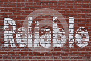 Red brick wall with white letters spelling reliable