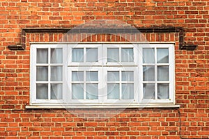 Red brick wall with white window