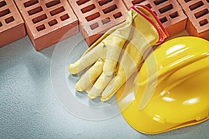 Red bricks safety gloves hard hat on concrete surface top view b