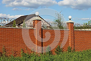 Red bricks wall of fence with white lanterns in green grass
