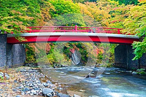 A red bridge across river in autumn, Japan