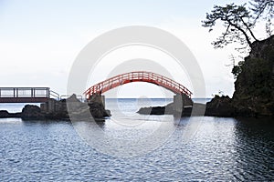 Red bridge conecting volcanic rock formations in Sado Island in Yajima and Kyojima. photo