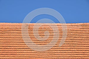 Red brown ceramic roof tiles over blue sky