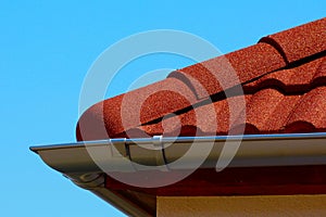 red brown color sandy textured modern concrete roof tile closeup detail. half round ridge tiles