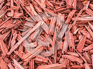 Red and brown pieces of tree wood texture background. Mulch ground
