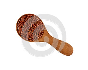 Red brown raw rice in wooden scoop on white