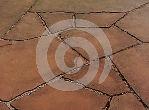 Red brown sand stone paving. smooth flat sandy texture & grit and uneven joints.