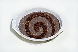 Red or brown Sesame seeds isolated in a pot on white background