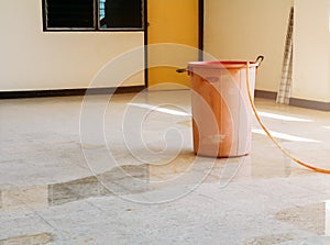 Red bucket underlie water leak interior office building in from Ceiling