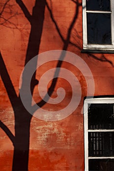 Red building part with black shadow from a tree