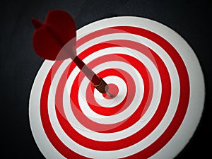 Red bullseye dart arrow hitting target center of dartboard. Concept of success, target, goal, achievement