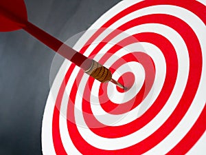 Red bullseye dart arrow hitting target center of dartboard. Concept of success, target, goal, achievement