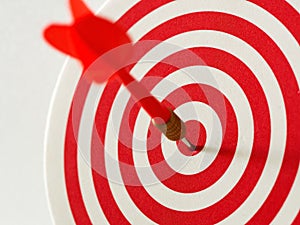 Red bullseye dart arrow hitting target center of dartboard. Concept of success, target, goal, achievement.