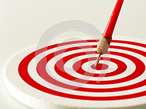 Red bullseye dart arrow hitting target center of dartboard. Concept of success, target, goal, achievement.