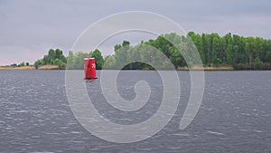 Red buoy floating on water surface