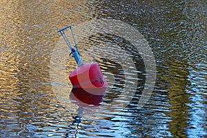 A red buoy floats on the surface of the lake