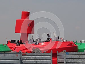 Red buoy with the letter C on it in the harbor of Antwerp