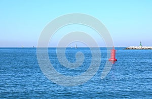 red buoy in the middle of the sea to indicate the presence of th