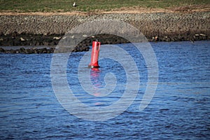 Red buoy in the river Hollandse IJssel in Gouderak the NEtherlands