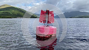 Red buoy in water to direct boats to safety in Loch Lomond