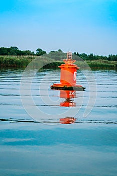A red buoy on the waves of the river. River navigation