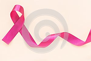 Red burgundy ribbon bow curl on isolated pastel beige background with copy space, symbol of Multiple Myeloma or Plasma cell cancer