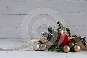 Red burning candle with christmas decoration, fir tree, baubles