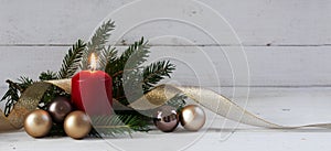 Red burning candle with christmas decoration, fir tree, baubles