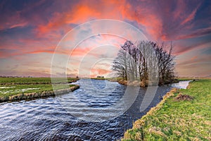 Red burning sky at sunset above a flat Dutch landscape