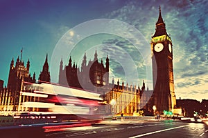 Red bus, Big Ben and Westminster Palace in London, the UK. at night. Moon shining. Vintage