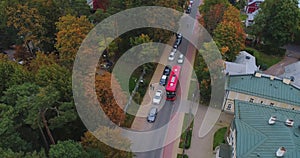 Red bus dribe on the city road drone flight, yellow tree