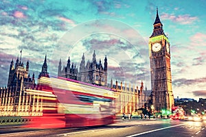 Red bus on Westminster bridge next to Big Ben in London, the UK at night