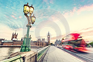 Red bus on Westminster bridge next to Big Ben in London, the UK at sunset