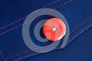 Red button on blue textile