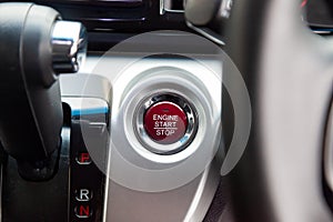 Red Button start and turn off the ignition of the car engine close-up on the dashboard, electric key, of modern design black and