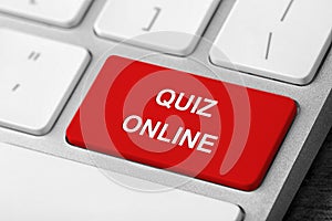 Red button with text QUIZ ONLINE on modern computer keyboard, closeup view