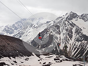 Red cable car on the background of mountains covered with snow. aerial photography