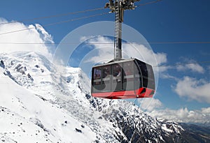 Red cable car in the background of the winter mountains