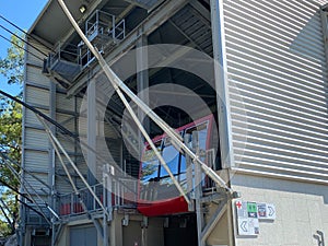 Red cable car cabin over the snow mountain peak