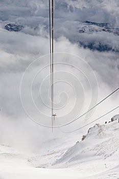 Red cable car descend from mountain peak