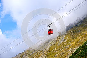 Red cable car over the mountains
