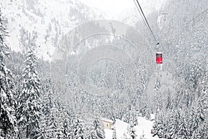 Red cable car in winter alpine landscape