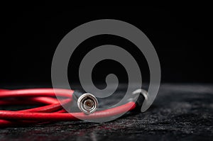 Red cable for transferring sdi signal through bnc connector on a dark background