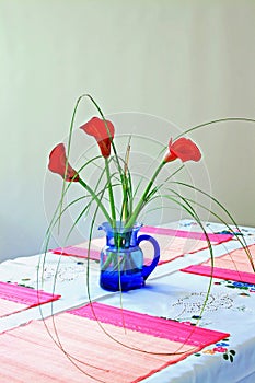 Red callas on blue vase photo