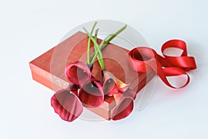 Red callas on a red gift box